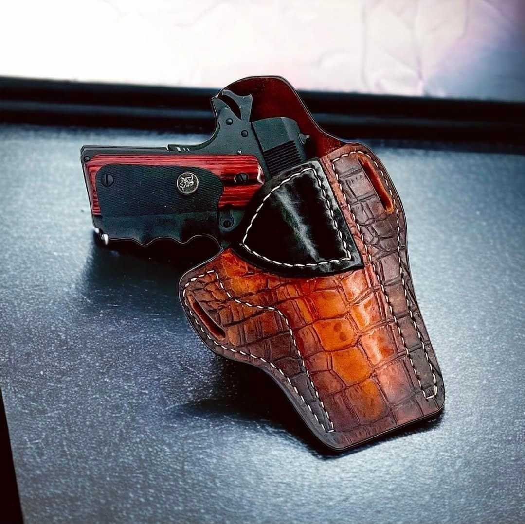 Leather gun holster with pistol on textured surface.